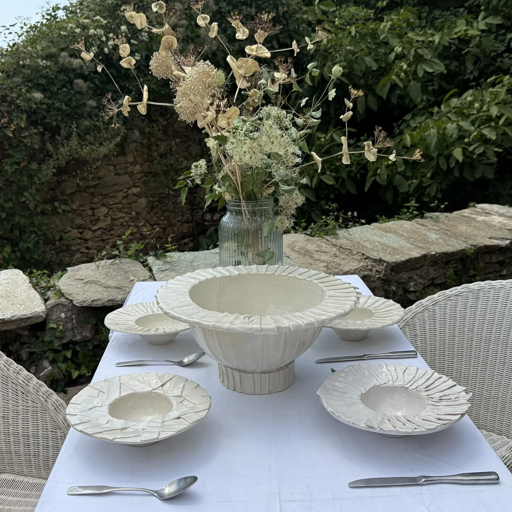 Sculptural Fabric Senses ceramic table setting among flowers