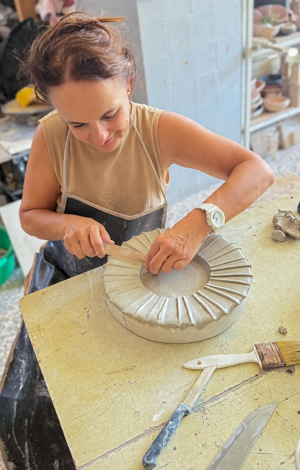 Katharina Kriener working on a ceramic plate